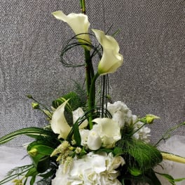 Tall white floral arrangement with calla lilies and hydrangeas