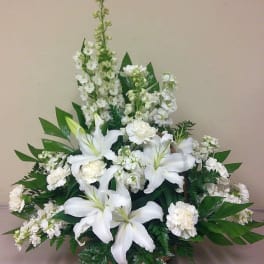 White lilies and carnations arranged in a basket