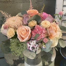 Peach and pink rose bouquet with eucalyptus in a vase