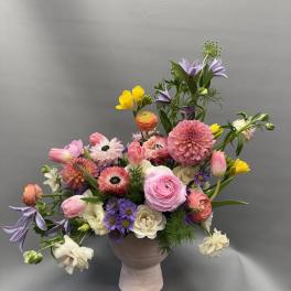 Mixed bouquet in a pink vase with pink, purple, white, and yellow flowers