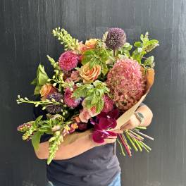 Handheld bouquet with pink hydrangea, peach roses, and purple allium