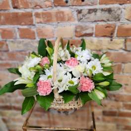 Basket arrangement of white and pink flowers with greenery