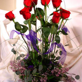 Tall bouquet of red roses with purple ribbon and pink filler flowers