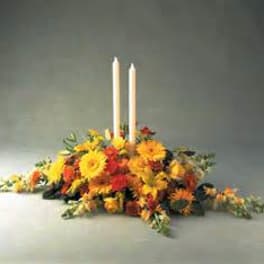 Low floral centerpiece with two white taper candles