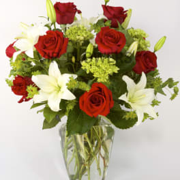 Red roses and white lilies in a clear glass vase