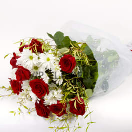 Bouquet of red roses and white daisies wrapped in white mesh