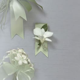 White floral corsage and ribbon boutonniere on pale green ribbons