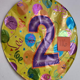 Round yellow balloon with a large purple number 2 and confetti print