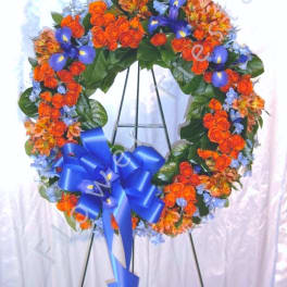 Heart-shaped floral wreath with orange and blue flowers on an easel