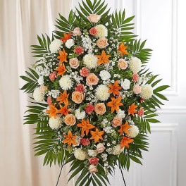 Large standing floral spray with orange lilies and peach roses