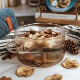Glass mug filled with dried fruit slices and spices on a table