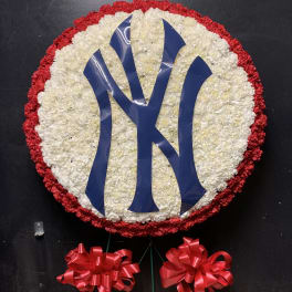 Round floral wreath with a blue monogram and red ribbon bows