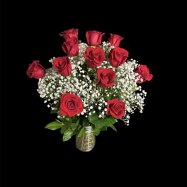 Bouquet of red roses and white baby's breath in a glass vase