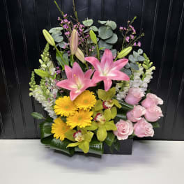 Mixed floral arrangement with pink lilies, yellow gerberas, and pink roses