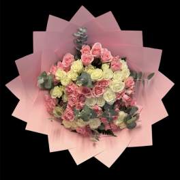 Bouquet of pink and cream roses wrapped in pink paper