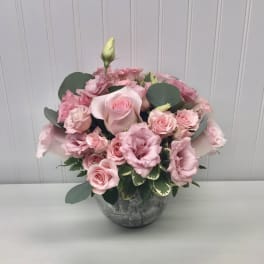 Pink roses and lisianthus arranged in a gray vase