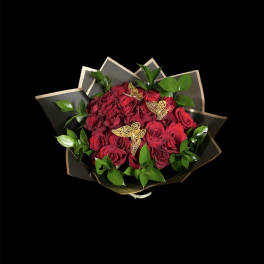 Bouquet of red roses with green foliage and butterfly accents