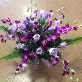 Bouquet of purple orchids and lavender roses in a glass vase