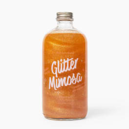 Bottle of orange glitter mimosa drink with a metal cap