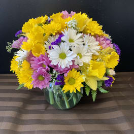Mixed bouquet of daisies and chrysanthemums in a glass vase