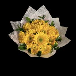 Bouquet of yellow daisies wrapped in patterned paper