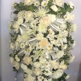 White floral standing spray with roses, daisies, and lilies