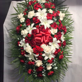 Red and white floral standing spray with a red bow