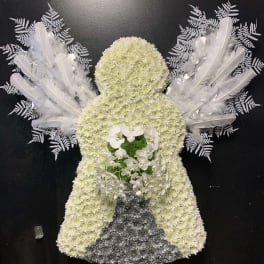 Angel-shaped floral tribute with white flowers, feathers, and orchids on a black background
