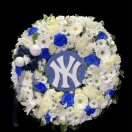 Round floral wreath with white flowers, blue roses, and a Yankees logo center