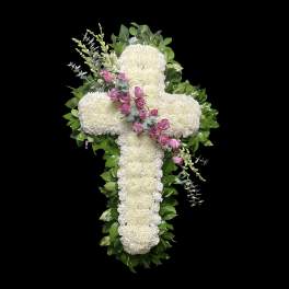 White floral cross with pink roses and greenery on a black background