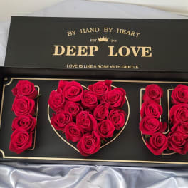 Red roses arranged to spell I LOVE U in a black gift box