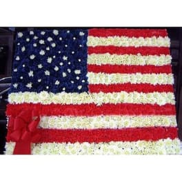 Floral arrangement shaped like the American flag with red, white, and blue flowers