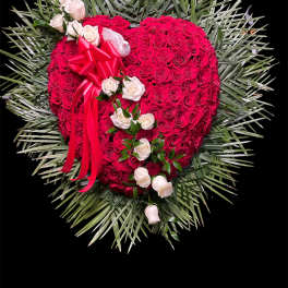 Heart-shaped red rose arrangement with white roses and a red ribbon