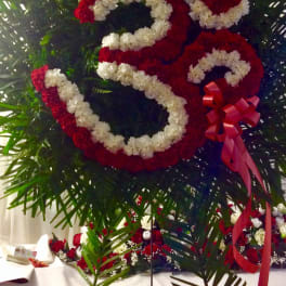 Large floral number 25 made of red and white flowers with a red ribbon