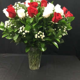 Red and white roses arranged in a clear glass vase