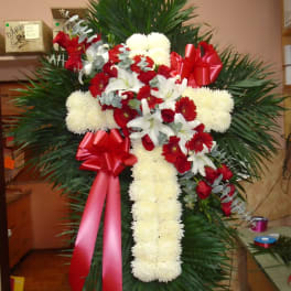 Standing floral cross with red and white flowers and red ribbons