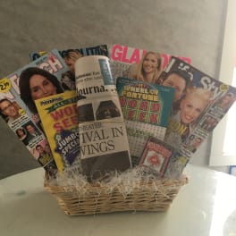 Basket filled with magazines and a rolled newspaper