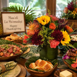 Colorful floral centerpiece in a green vase on a Thanksgiving table