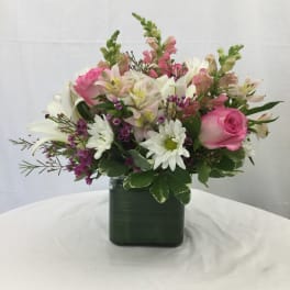 Pink and white mixed flower arrangement in a square vase