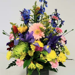 Colorful mixed flower arrangement in a dark green vase