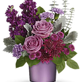 Purple and pink flower arrangement in a lavender vase