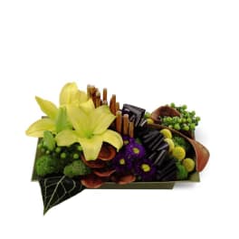 Yellow lilies arranged in a rectangular box with purple accents