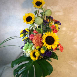 Tall mixed bouquet with sunflowers in a glass vase