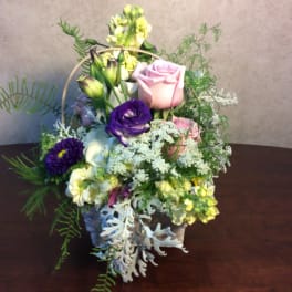 Mixed flower basket with pink and purple roses and white blooms