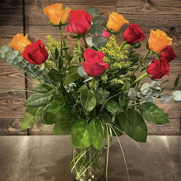 Bouquet of red and orange roses in a clear glass vase