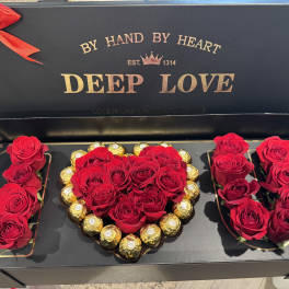 Red roses and chocolates arranged in a heart-shaped gift box