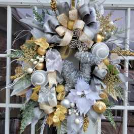 Decorative holiday wreath with silver, gold, and white ribbons and ornaments