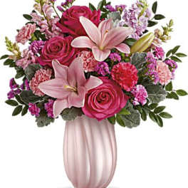 Pink roses and lilies arranged in a pink vase