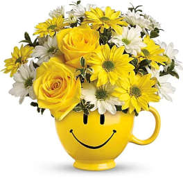 Yellow and white flowers arranged in a smiley-face mug