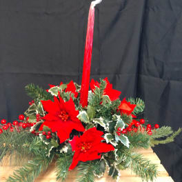 Holiday centerpiece with red poinsettias and evergreen branches